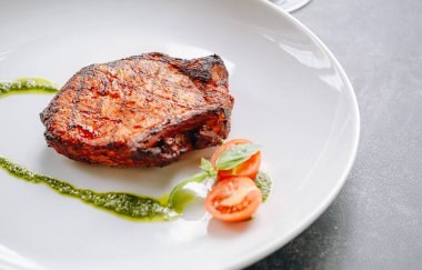 Baharatlı kızarmış domuz eti, zeytinyağı ve fesleğen sosu.