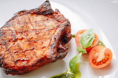 Baharatlı kızarmış domuz eti, zeytinyağı ve fesleğen sosu.