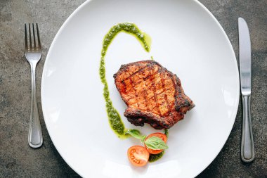 Baharatlı kızarmış domuz eti, zeytinyağı ve fesleğen sosu.