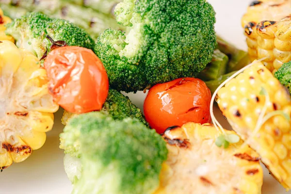 Kızarmış sebze, mısır, domates, brokoli ve kuşkonmaz.