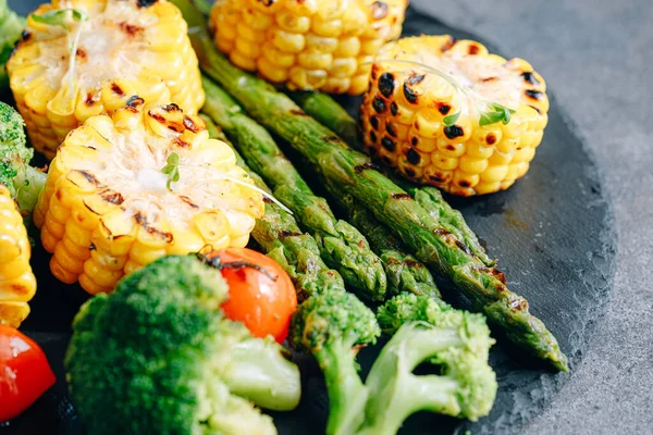 Kızarmış sebze, mısır, domates, brokoli ve kuşkonmaz.
