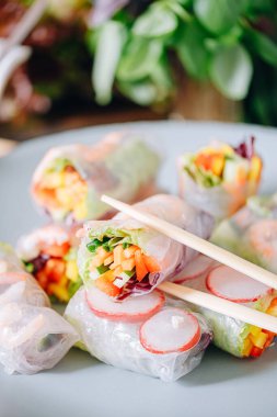 fresh springrolls with vegetables and shrimps. a healthy dish of rice paper and fresh organic vegetables clipart