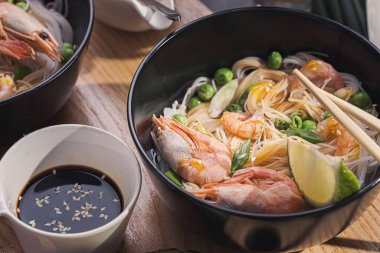 İki kişilik Asya yemeği. Asya mutfağı, deniz ürünleri ve sebzeli pirinç eriştesi.