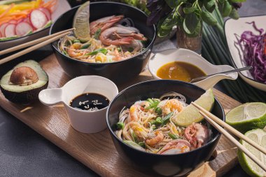 İki kişilik Asya yemeği. Asya mutfağı, deniz ürünleri ve sebzeli pirinç eriştesi.