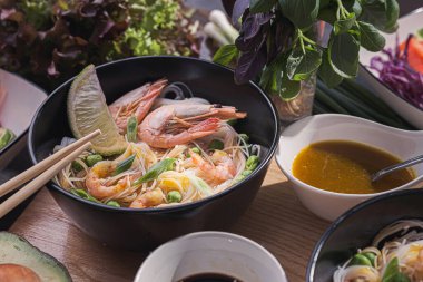 İki kişilik Asya yemeği. Asya mutfağı, deniz ürünleri ve sebzeli pirinç eriştesi.