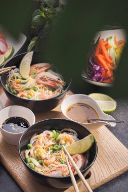 İki kişilik Asya yemeği. Asya mutfağı, deniz ürünleri ve sebzeli pirinç eriştesi.