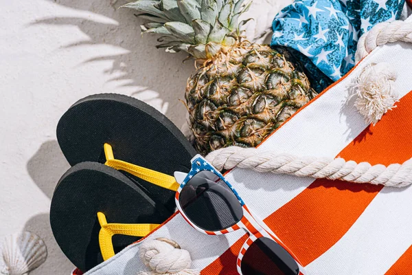海滩袋 沙滩上有菠萝太阳镜和白色沙滩上的泳衣 — 图库照片