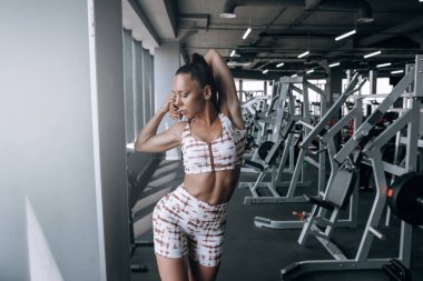 Siyah kadın spor aletleri üzerinde çalışmadan önce kaslarını ısıtıyor.