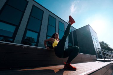 Atletik fit Afro-Amerikan kadın dışarıda spor yapıyor.