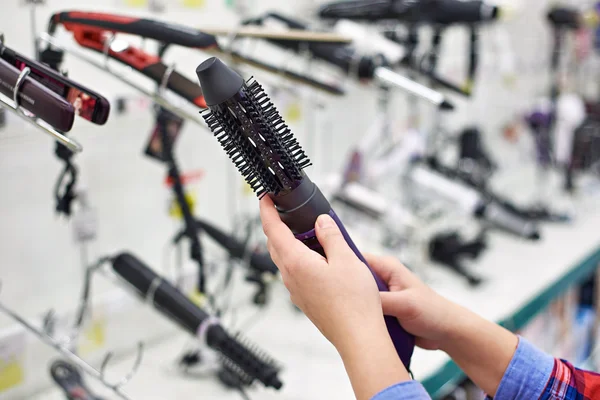 Mulher escolhe um secador de cabelo — Fotografia de Stock