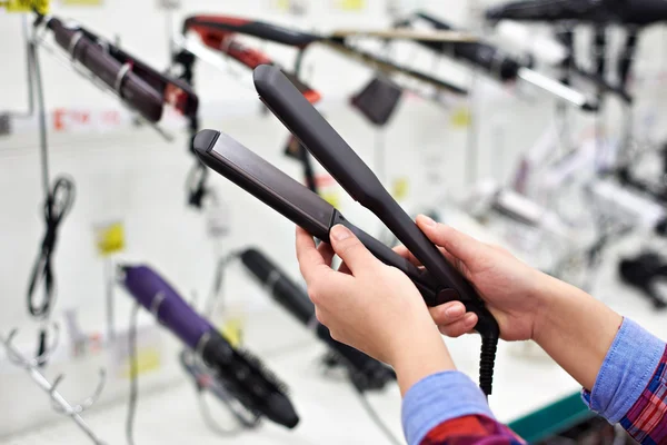 Vrouw handen met Tang curling voor haar — Stockfoto