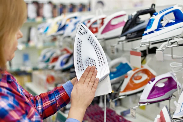Vrouw winkelen voor ijzer in winkel — Stockfoto