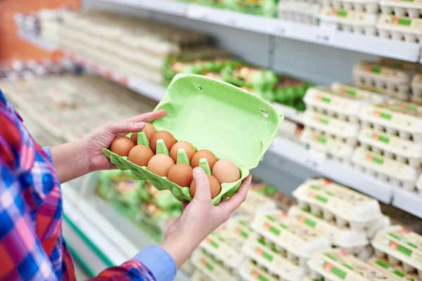 Em mãos de mulher que empacota ovos no supermercado — Fotografia de Stock