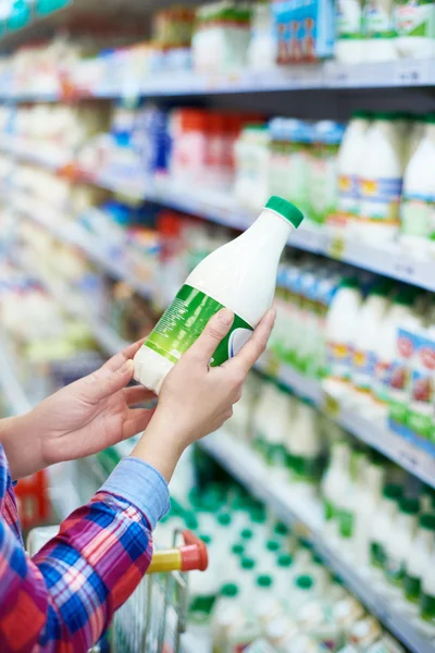 Žena nakupovat mléko v úložišti — Stock fotografie