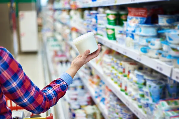 Mujer compras crema agria en la tienda —  Fotos de Stock