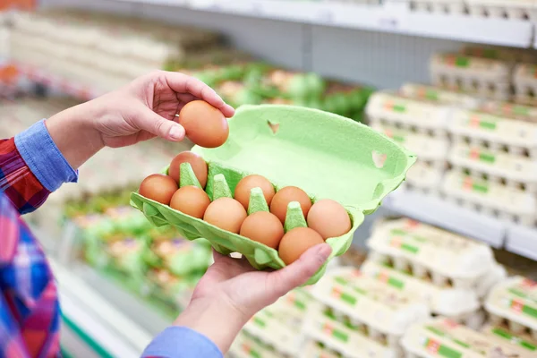 In hands of woman packing eggs in supermarket — Stock Photo, Image