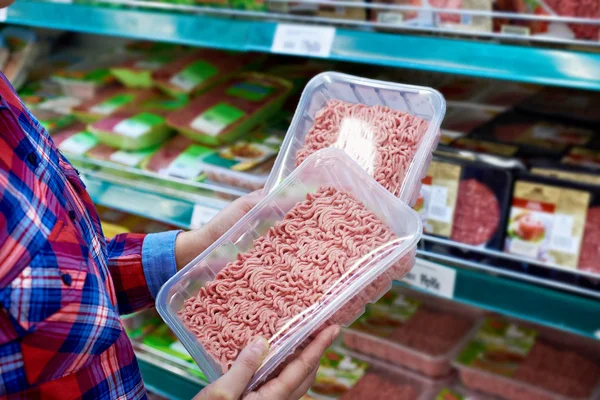 Kupující vybírá mleté maso v úložišti — Stock fotografie