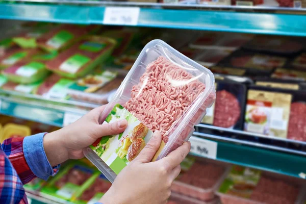 Buyer chooses minced meat in store — Stock Photo, Image