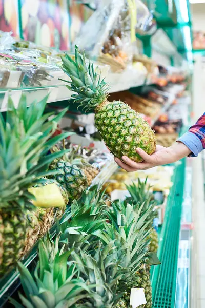 Покупатель с ананасом в магазине — стоковое фото