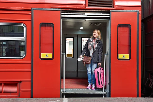 Kobieta turysta walizka wychodzi z pociągu na stacji — Zdjęcie stockowe