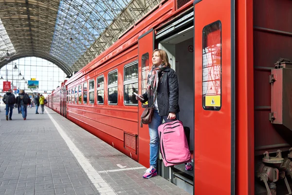 Mulher turista com mala saindo do trem na estação — Fotografia de Stock