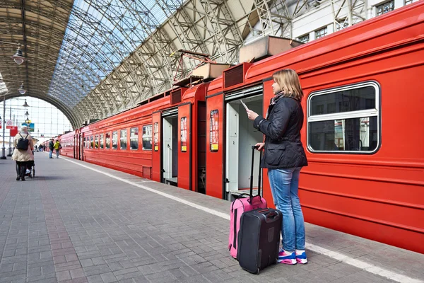 Vrouw met koffers in de buurt van trein wachten op vertrek op station — Stockfoto