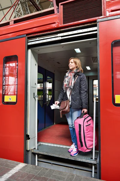 Mulher turista com mala saindo do trem na estação — Fotografia de Stock