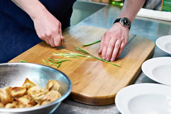 Cook corta cebollas verdes para servir albóndigas —  Fotos de Stock
