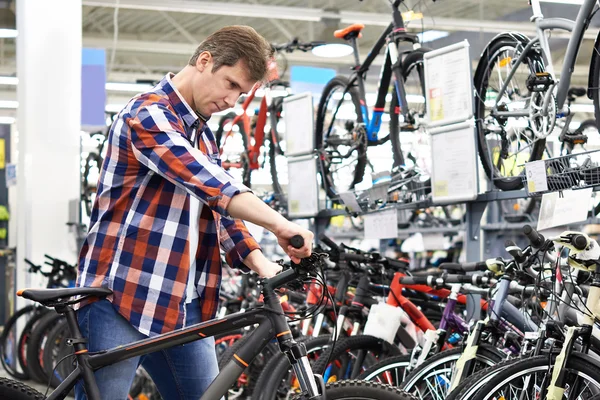 Homme vérifie vélo avant d'acheter dans la boutique — Photo