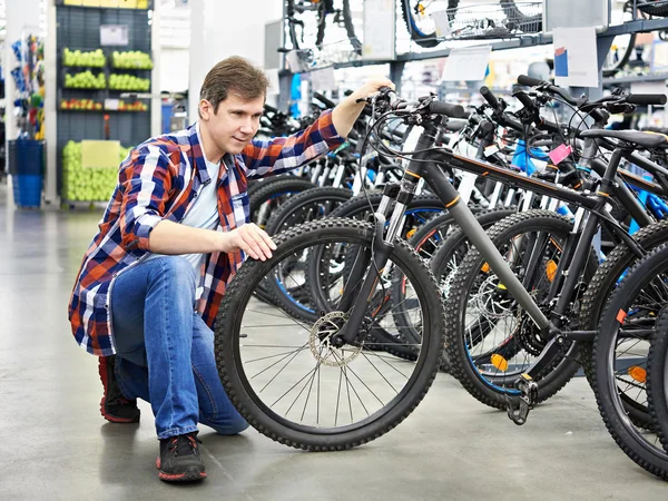 Homme vérifie vélo avant d'acheter dans la boutique — Photo