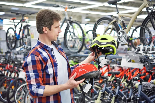 Homem escolhe capacete para ciclismo — Fotografia de Stock