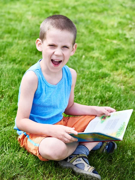 Kleiner Junge liest im Freien in Buch — Stockfoto