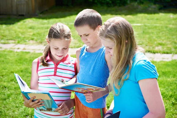 Vrienden kinderen lezen van boeken buiten — Stockfoto