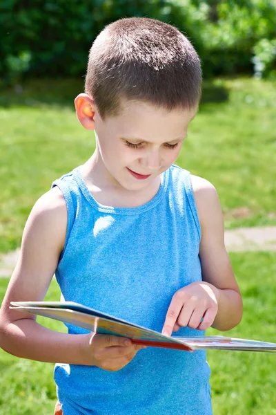 Kleiner Junge liest Bücher im Freien — Stockfoto