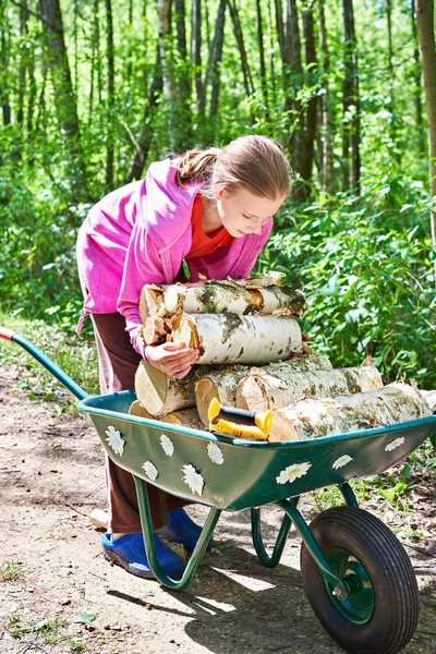 Ung flicka bär ved från skog — Stockfoto