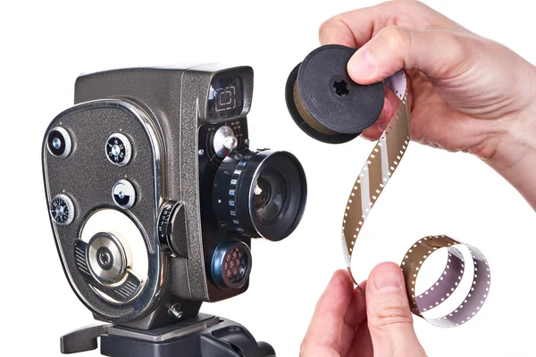 Cámara de película mecánica retro y tira de película en las manos del operador —  Fotos de Stock