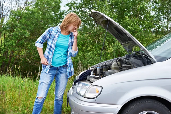 Frau mit Schraubenschlüssel nahe kaputtem Auto — Stockfoto