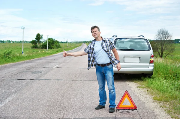 Man standing on road near emergency sign and waiting help — Stock Photo, Image