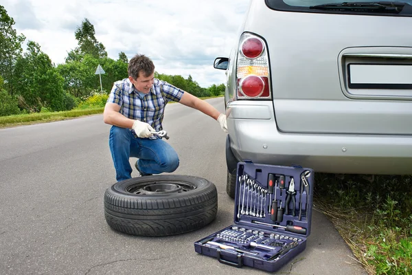 Uomo che cambia ruota di auto — Foto Stock