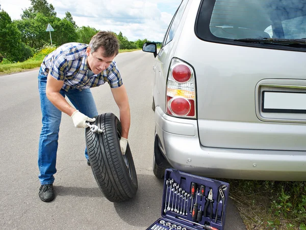 Hombre cambiando la rueda del coche — Foto de Stock