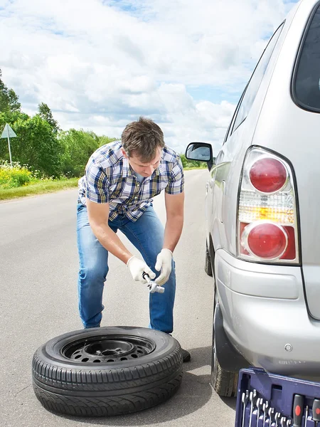 Homme changeant un pneu de rechange de voiture — Photo