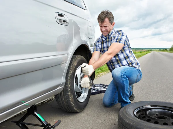 Homme changeant un pneu de rechange de voiture — Photo