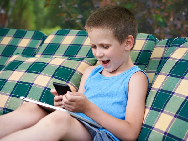 Мальчик со смартфоном и планшетным ПК — стоковое фото