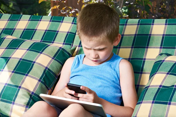 Malý chlapec s telefon a tablet pc — Stock fotografie
