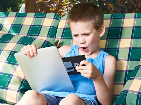 Little boy with floppy disk and tablet pc — Stock Photo, Image