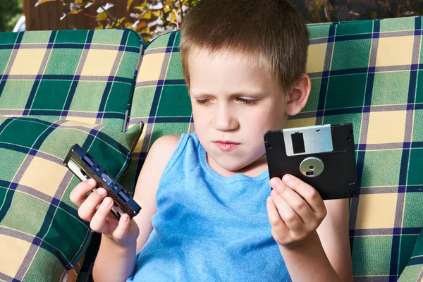 Little boy with floppy disk and audio cassette — Stock Photo, Image