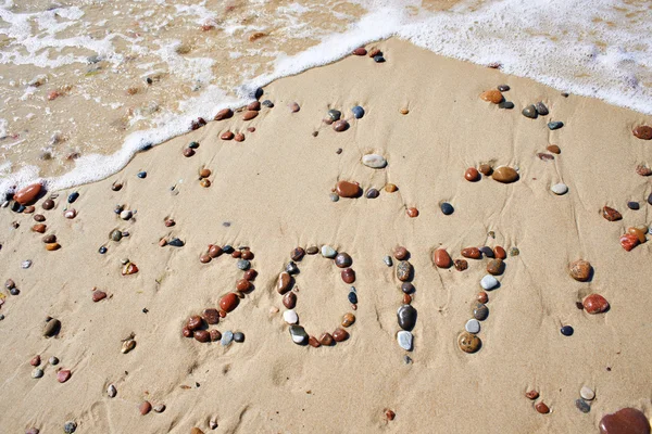 Počet mokré kameny 2017 na písčité pláži — Stock fotografie