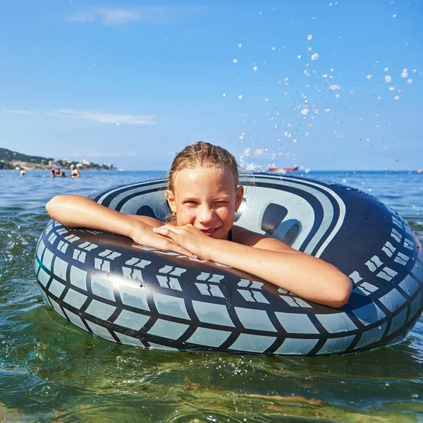 Szczęśliwa dziewczyna z pontony zabawki w morze — Zdjęcie stockowe