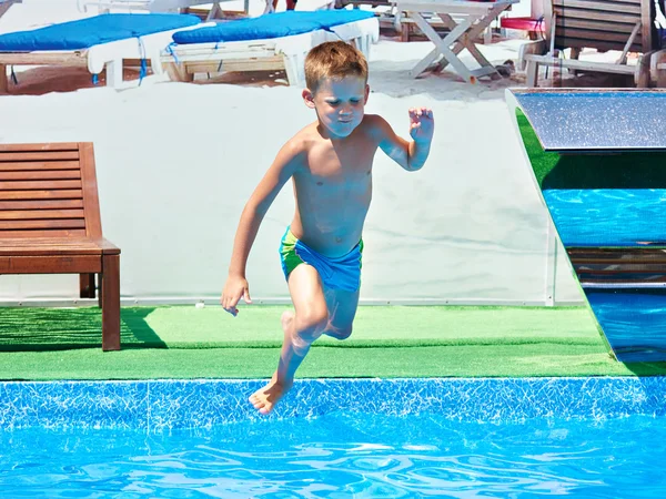 Kleine jongen springen in het zwembad van het resort — Stockfoto