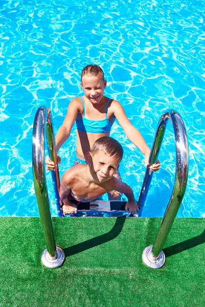 Chica y niño en la piscina del complejo —  Fotos de Stock